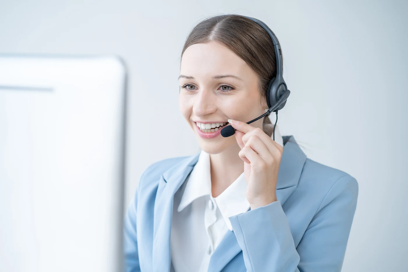 Mitarbeiterin mit Headset am Arbeitsplatz