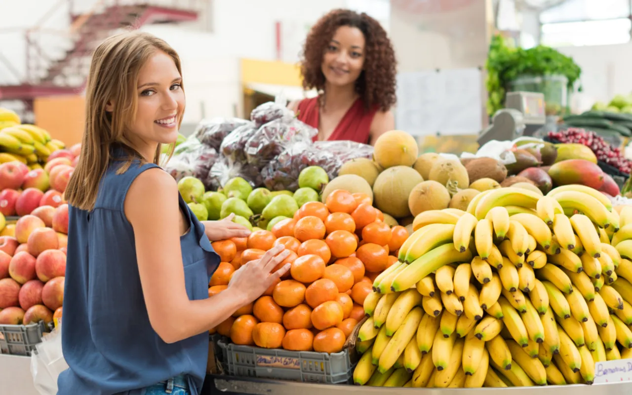 Mitarbeiterin an der Obst- und Gemüseauslage im Einzelhandel